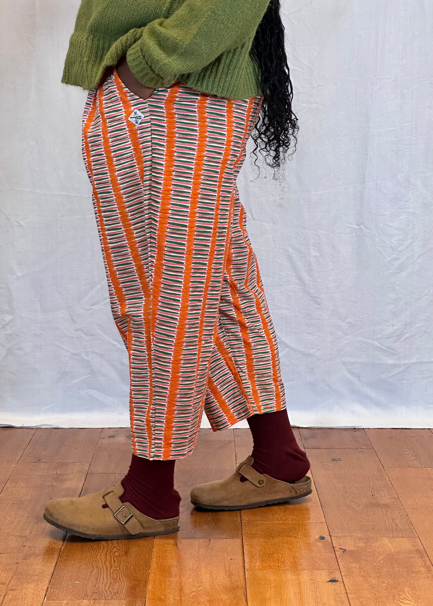Person wearing patterned trousers on wooden floor visible. Humphries and Begg