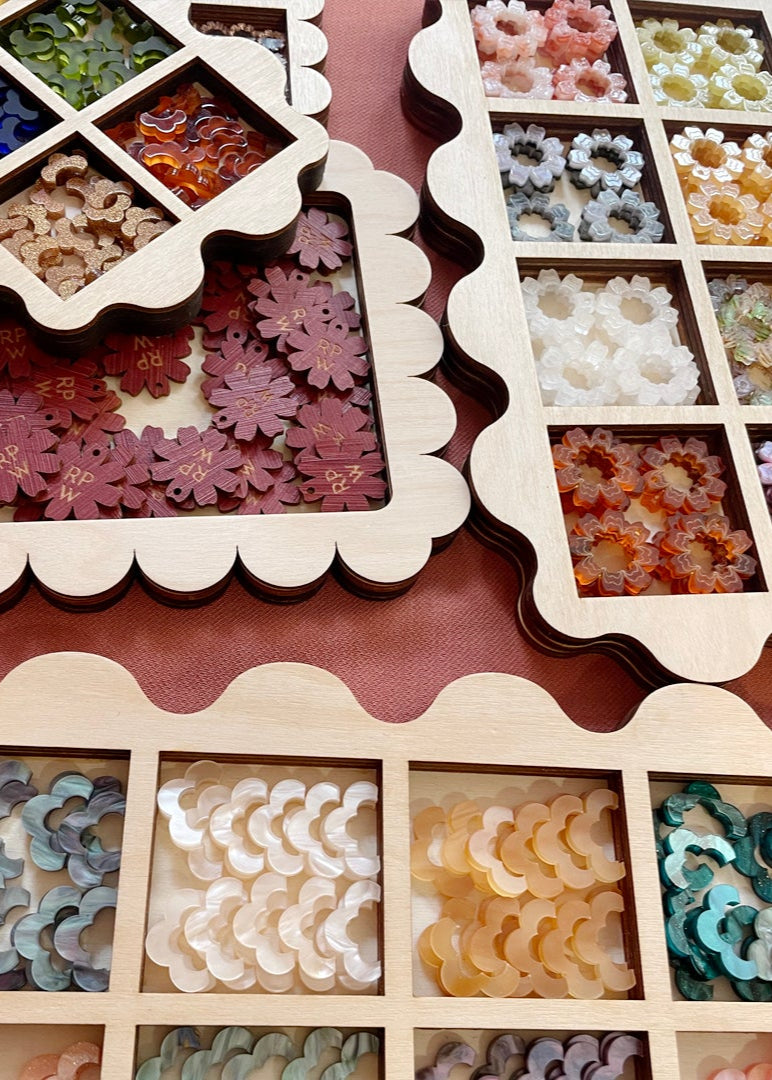 Floral earrings in a box with a display of various floral designs.