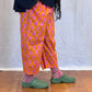Person wearing colourful pants and green shoes on a wooden floor. Humphries and Begg