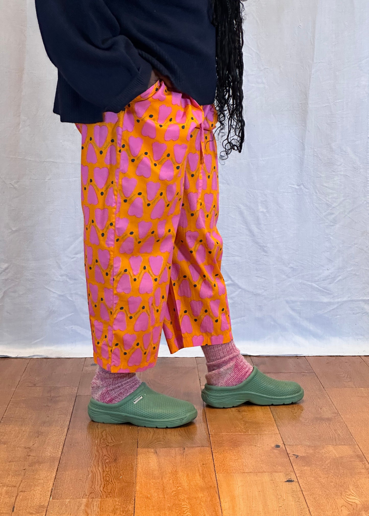 Person wearing colourful pants and green shoes on a wooden floor. Humphries and Begg
